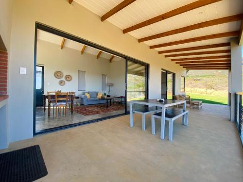 comedor y sala de estar con puertas correderas de cristal en Sneeukop Mountain Cottage, en Paarl