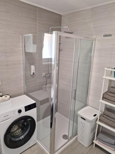 een badkamer met een wasmachine en een douche bij Mimi in Hvar