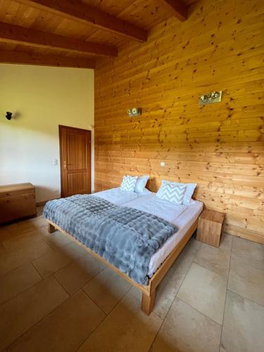 a bedroom with a bed in a wooden wall at Ferienhaus an der Drau in Sankt Oswald