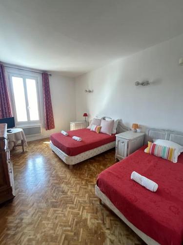 - 2 lits dans une chambre avec des draps rouges dans l'établissement 