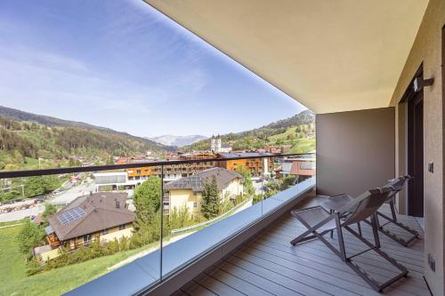 a balcony with a chair and a view at Brixental Suites Hopfgarten by ALPS RESORTS in Hopfgarten im Brixental