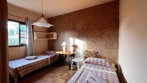 a bedroom with two beds and a desk with a chair at Casa Christine in Playa Migjorn