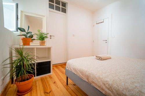 a bedroom with a bed and two potted plants at Lisbon stays in Lisbon