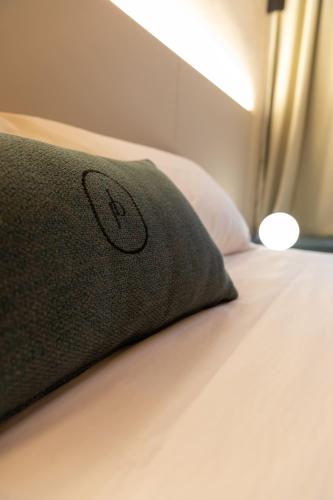 a black pillow sitting on top of a bed at Palais Bernadette in Parma