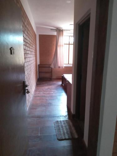 a hallway with a door and a brick wall at Windy Hanthana in Kandy