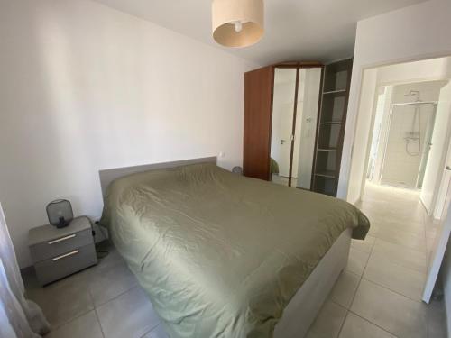 une chambre avec un lit avec une couette verte dans l'établissement Maison climatisée 47 m2 Biscarrosse proche lac et océan, à Biscarrosse