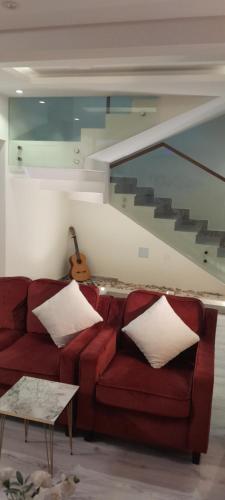 ein Wohnzimmer mit einem roten Sofa und einer Treppe in der Unterkunft فلل سهم الرياض in Riad