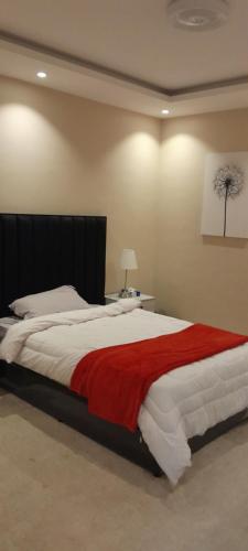 فلل سهم الرياض في الرياض: غرفة نوم بسرير كبير مع بطانية حمراء