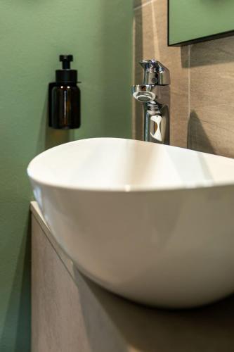 a white sink with a faucet in a bathroom at Palais Bernadette in Parma