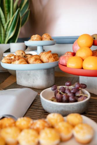 a table topped with plates of pastries and fruit at Hotel Soho in Landau in der Pfalz