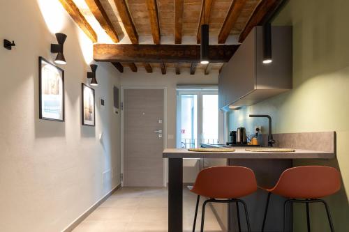 a kitchen with two orange chairs at a counter at Palais Bernadette in Parma