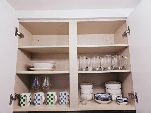 a cabinet filled with plates and bowls and glasses at Cozy spacious house in Seoul