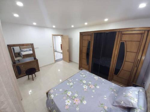 1 dormitorio con cama, tocador y espejo en Appartement vu sur mer, en Kolea