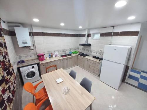 eine Küche mit einem Tisch und einem weißen Kühlschrank in der Unterkunft Appartement vu sur mer, in Kolea
