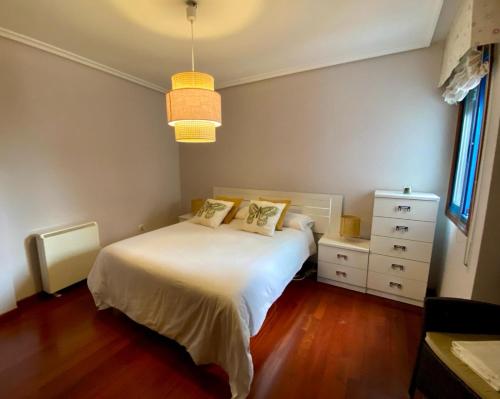 ein Schlafzimmer mit einem weißen Bett und einer Kommode in der Unterkunft PUNTA SALGUEIRÓN Vistas a la Ría - Navidad en Vigo sin Agobios- in Cangas