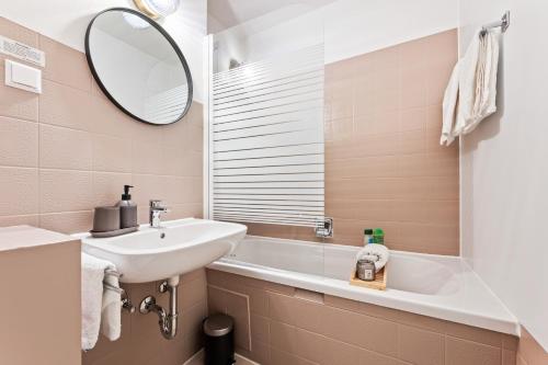 a bathroom with a sink and a mirror and a tub at IDYL kostenloser Privat-Parkplatz Wifi SmartTV Balkon in Ludwigsburg