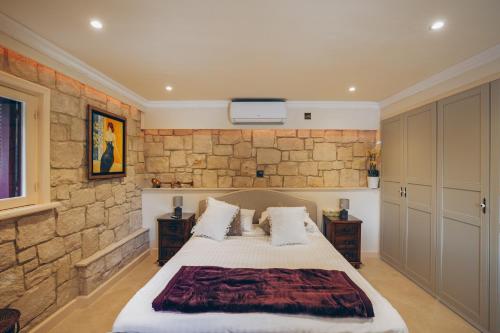 een slaapkamer met een bed en een stenen muur bij No 1 Mandria in Limassol