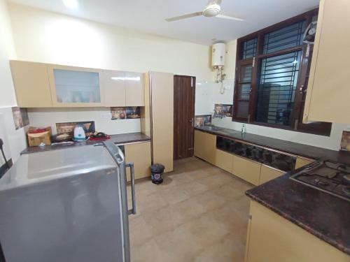a kitchen with a sink and a refrigerator at Osho home stay in Lucknow
