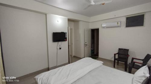 a bedroom with a bed and a tv on the wall at Osho home stay in Lucknow
