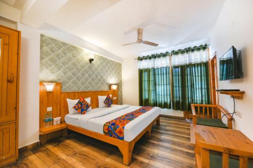 sypialnia z dużym łóżkiem i drewnianą podłogą w obiekcie WooibHotels The Kanchanikoot Manali w mieście Manāli
