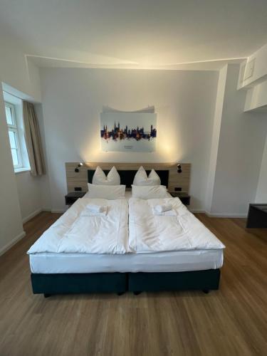a bedroom with a large bed with white sheets and pillows at Hopfenhotel am Adenauerufer in Bamberg