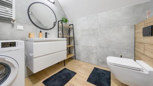a bathroom with a sink and a washing machine at Apartamenty Sun & Snow Na Różanej in Sianozety