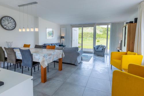 uma cozinha e sala de estar com mesa e cadeiras em Hogehilweg 16 vakantiehuis, Direct onder de duinen - eigen parkeerplaatsen em Domburg
