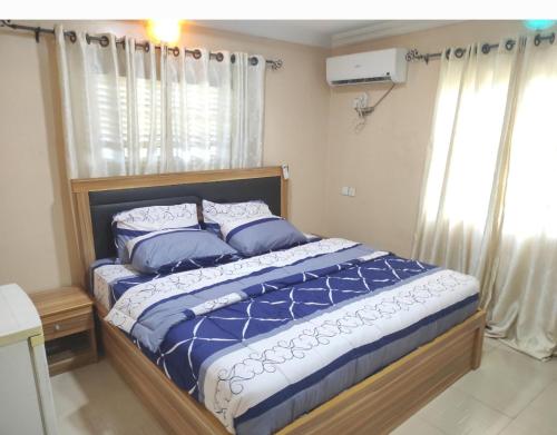 AbeokutaInviting 2-Bed House in Abeokuta的卧室里有一张床，床单和枕头都是蓝色的