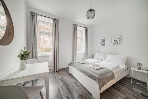 una camera bianca con letto bianco e scrivania di cute apartment in vienna a Vienna
