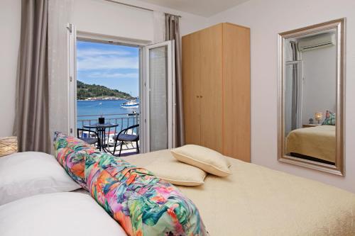 a bedroom with a bed and a view of the water at Sunshine Apartment Doda in Vela Luka