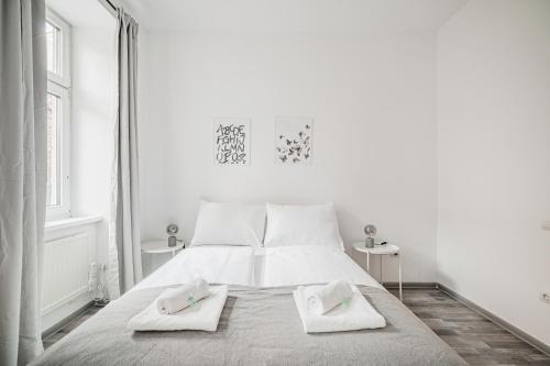 una camera bianca con un letto con due asciugamani di cute apartment in vienna a Vienna