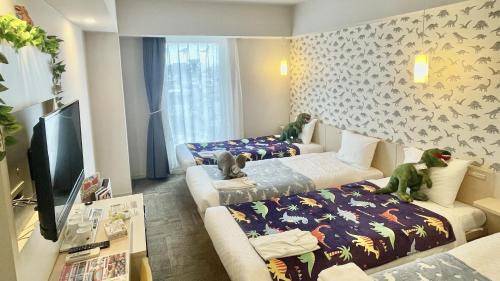 ein Wohnzimmer mit 2 Betten und einem TV in der Unterkunft Henn na Hotel Maihama Tokyo Bay in Urayasu
