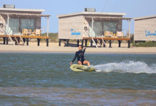 a woman riding a wave on a surfboard in the water at Océan Vagabond Lassarga in Dakhla