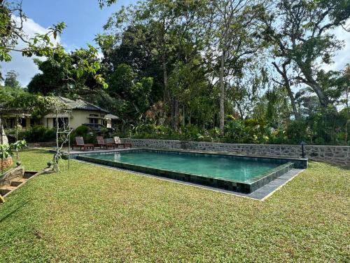 a swimming pool in the yard of a house at Ancoombra Tea Estate Bungalow in Matale