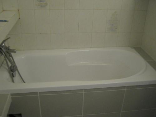 a bath tub in a bathroom with a tiled floor at Stare Żegrze 143 - Ekonomia i Komfort! in Poznań