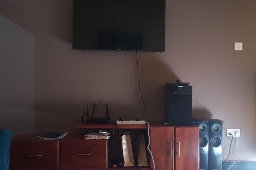 a living room with a tv on the wall at Home Waka in Wakiso