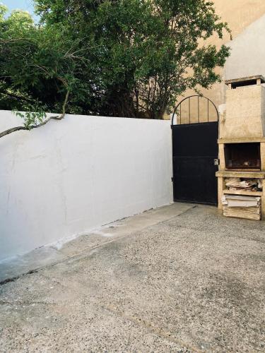 une clôture blanche avec un portail noir et une porte dans l'établissement Appartement au cœur du village, à Mondragon