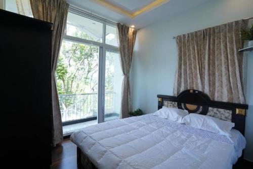 a bedroom with a bed and a large window at Casa de Selas in Coonoor