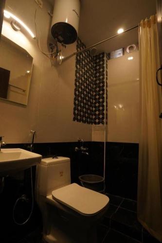 Un baño con inodoro, lavabo y ducha. en Casa de Selas, en Coonoor