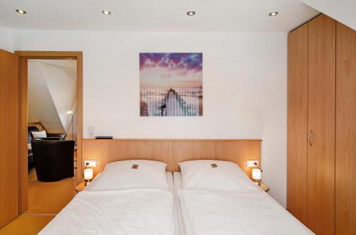 a bedroom with two beds and a painting on the wall at Huus Nördernee 2 in Norderney