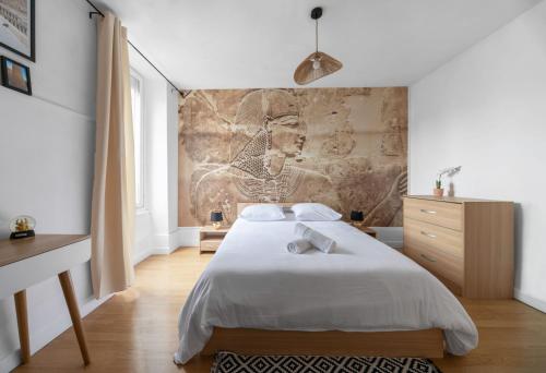 une chambre avec un lit et une peinture murale dans l'établissement Résidence Nature - Appartements design en centre ville, à Cusset