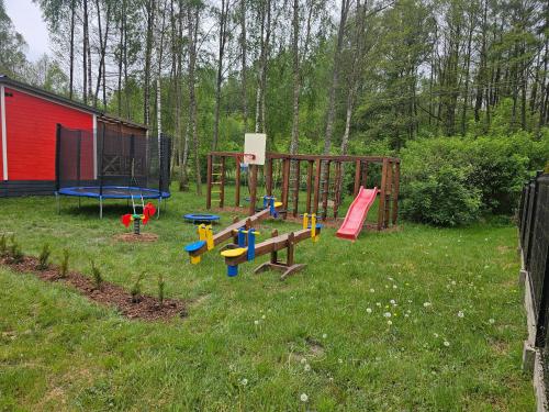 a group of playground equipment in a yard at Domek letniskowy - czerwony całoroczny in Stegers