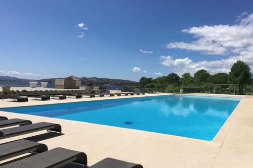 - une grande piscine avec des chaises longues à côté dans l'établissement T5, Perfettu 115m2 - Jardin, piscine, 8 pers, à Porto-Vecchio