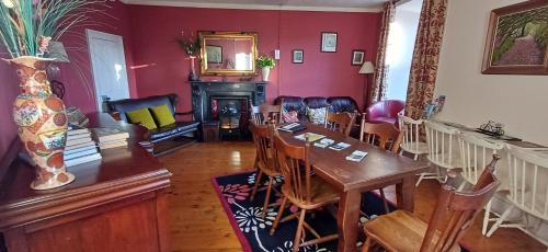 a dining room with a table and a fireplace at Fáilte Lodging Kenmare Town Centre in Kenmare