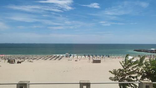 a beach with chairs and umbrellas and the ocean at ElStefanino House in Eforie Nord