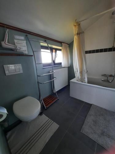 La salle de bains est pourvue de toilettes, d'un lavabo et d'une baignoire. dans l'établissement B&B Lomolen, à Aalter