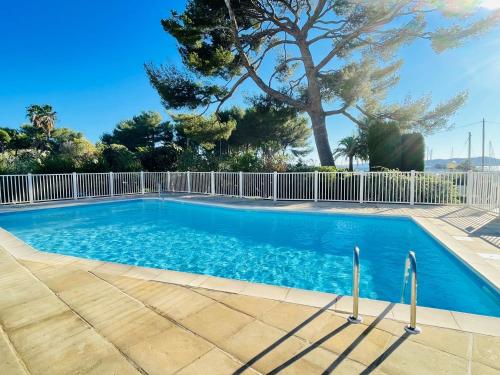 une piscine avec une clôture et un arbre dans l'établissement Appartement -piscine- proche bord de mer et centre, à Saint-Raphaël
