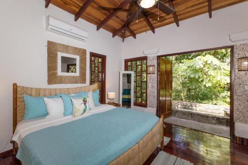 a bedroom with a bed and a large window at Restful Casa Quetzal Luxurious Rainforest Retreat in Quepos
