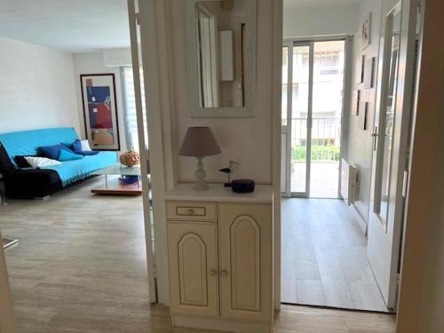 - un salon avec un canapé et une lampe sur une armoire dans l'établissement Appartement -piscine- proche bord de mer et centre, à Saint-Raphaël