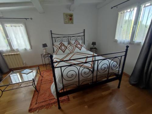 une chambre avec un lit et une table en verre dans l'établissement Gîte Les Amandiers, à Villedubert